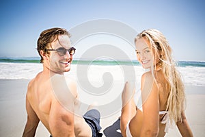 Happy couple sitting on the beach