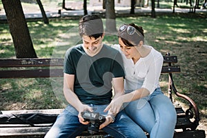 Happy couple sitting on bench and looking at DSLR camera