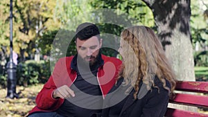 Happy couple sitting on bench in the park