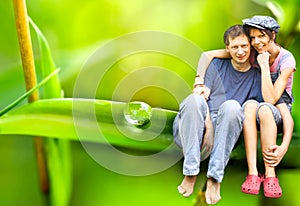 Happy Couple sitting on a big leaf