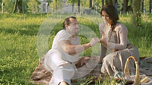 Happy couple sitting on blanket in the park