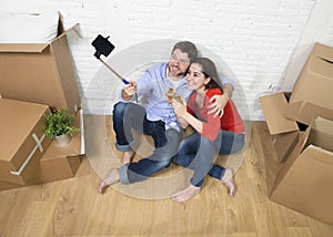 Happy couple sitting on floor celebrating champagne toast moving