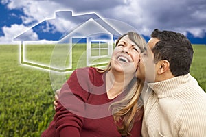 Happy Couple Sitting in Grass Field with Ghosted House Behind