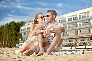 happy couple sitting on summer beach