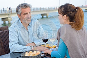 happy couple sitting at table in restaurant near by seaa