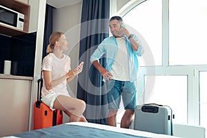 Happy couple sitting in their hotel room.