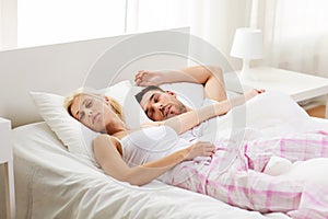 Happy couple sleeping in bed at home