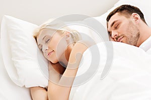 Happy couple sleeping in bed at home