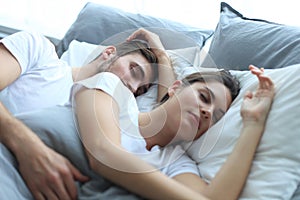 Happy couple sleeping in a comfortable bed at home.