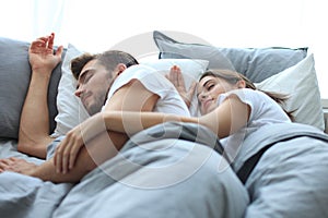 Happy couple sleeping in a comfortable bed at home.