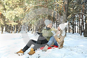 Happy couple sleighing outdoors on winter day