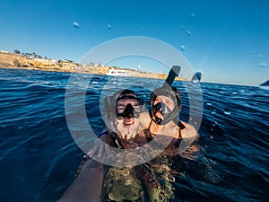 Happy couple snorkeling in Red sea and taking selfie