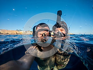 Happy couple snorkeling in Red sea and taking selfie