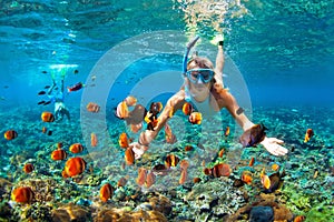 Happy couple snorkeling underwater over coral reef photo