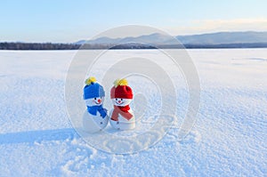 Happy couple of snowman in love standing on the snow. Writings 2019. Landscape with mountains in the cold winter day