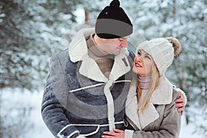 Happy couple spending good day outdoor in winter forest