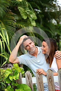 Happy couple standing in front of tropical garden