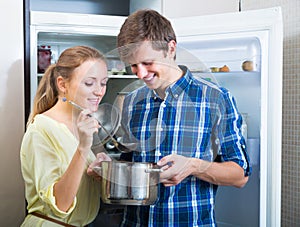 Happy couple standing near refrigerator photo