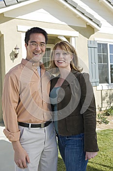 Happy Couple Standing Outside Their New House