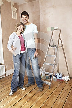 Happy Couple Standing In Unrenovated Room photo
