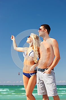 Happy couple in sunglasses on the beach