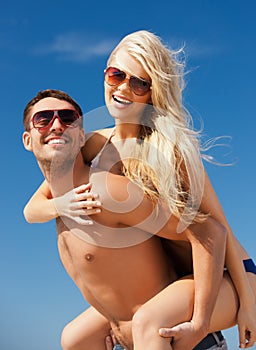 Happy couple in sunglasses on the beach