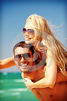 Happy couple in sunglasses on the beach