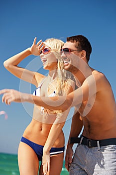 happy couple in sunglasses on the beach