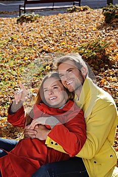 Happy Couple in sunny Autumn Park. Fall. Young Family Having Fun Outdoors. Yellow Trees and Leaves. Laughing Man and Woman outside