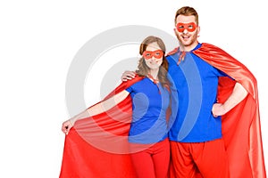 happy couple of superheroes standing together and smiling at camera
