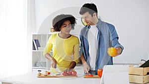 Happy couple with tablet pc cooking food at home