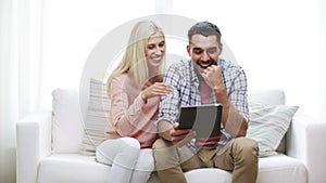 Happy couple with tablet pc at home