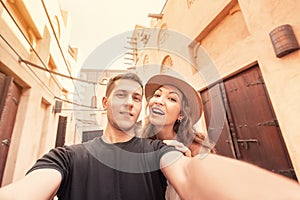 Happy couple takes a selfie against the backdrop of ancient Arabic architecture in the old town of Dubai. Honeymoon journey