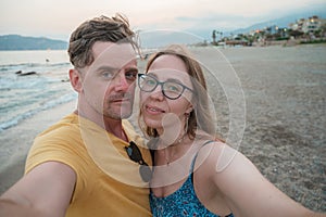 Happy couple taking a photo on a beach