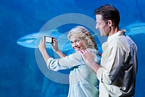 Happy couple taking a picture of fishes