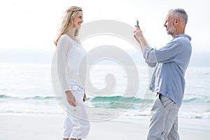 Happy couple taking pictures with mobile phone