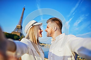 Happy couple taking selfie near the Eiffel tower