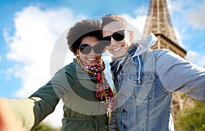 Happy couple taking selfie over eiffel tower