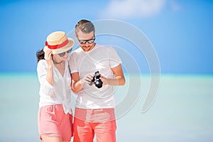 Happy couple taking a selfie photo on white beach. Two adults enjoying their vacation on tropical exotic beach