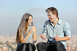 Happy couple talking in a city outskirts photo