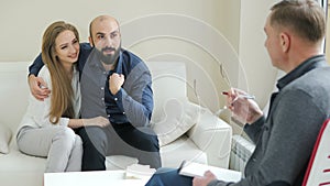 Happy couple talking to a psychologist before breaking up at a therapy session, consulting family relationships expert