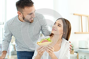 Happy couple with tasty sandwich