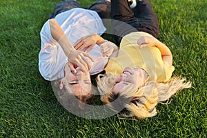 Happy couple of teenagers on green grass