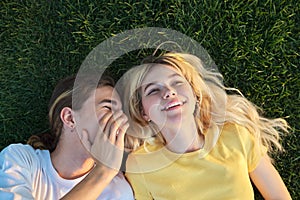 Happy couple of teenagers on green grass