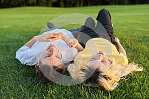 Happy couple of teenagers on green grass