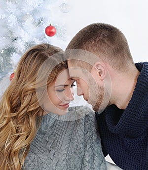 Happy couple tender embrace near Christmas tree
