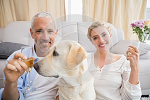 Happy couple with their pet dog drinking champagne