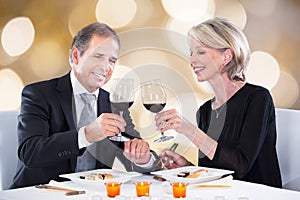 Happy couple toasting wineglasses in restaurant