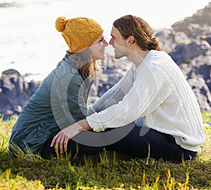 Happy, couple and together in nature or sitting on grass, hilltop and scenery or people looking with love. Care, smile