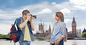 Happy couple of tourists with backpacks and camera